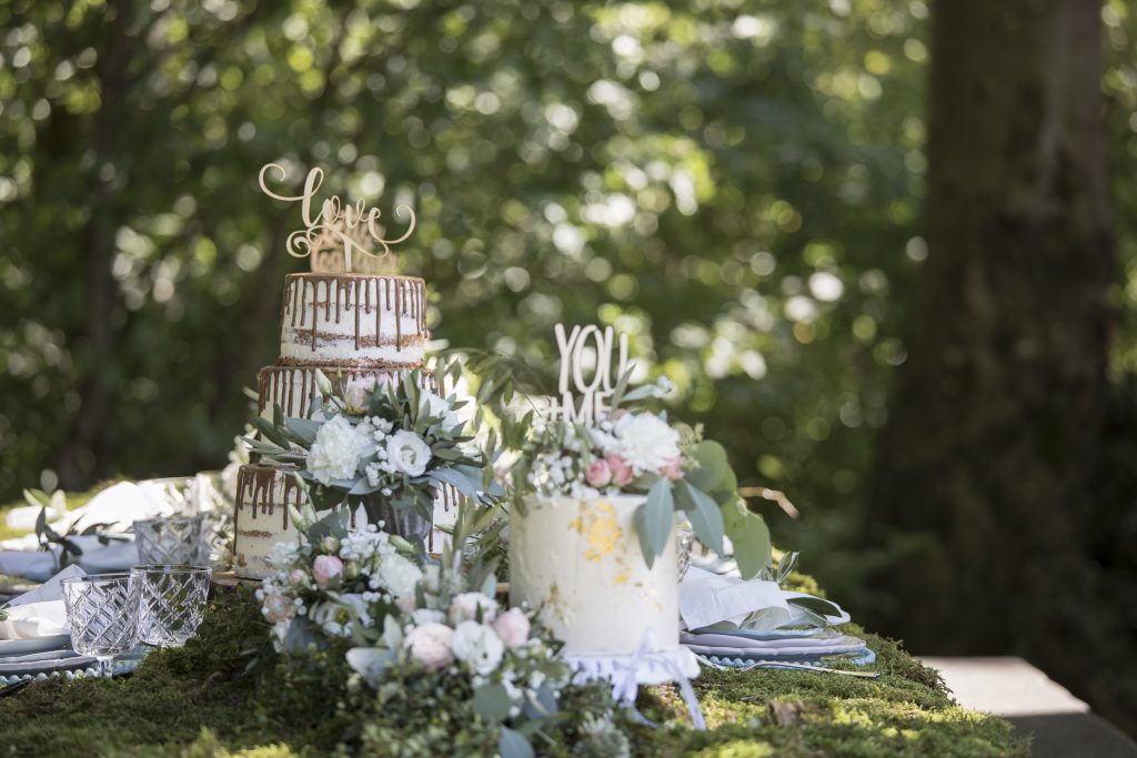 verschiedenen Hochzeitstorten auf mit Moos bedecktem Tisch