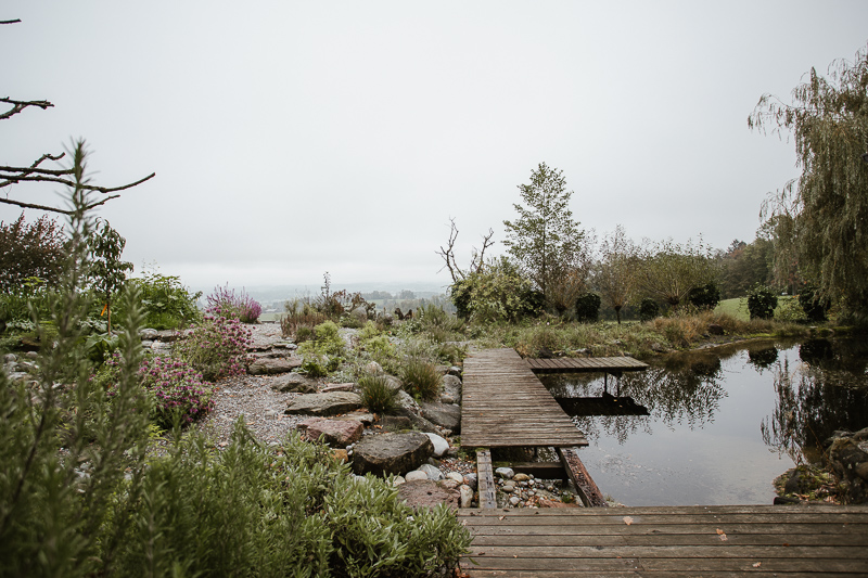 Holzsteg am Wasser in der Permakulturanlage.
