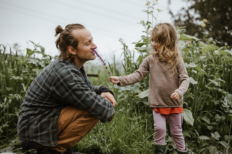Lucas und seine Tochter zwischen den Beeten. Authentisches Porträt für die Reportage.
