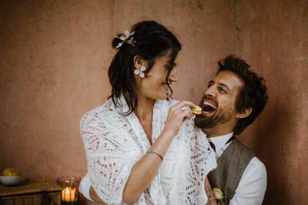Lachendes Brauptaar beim Essen von Zitronenmacarons - aufgenommen von Stephanie Wittmer Fotografie