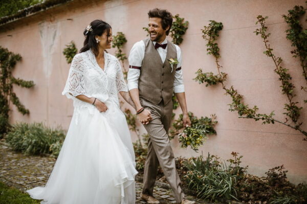 Brautpaar lacht vor der mediterranen Mauer des Schlössli Utenberg Luzern