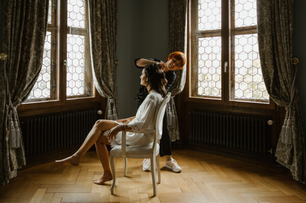 Braut wird im Blauen Zimmer des Schlössli Utenberg für die Hochzeit frisiert.
