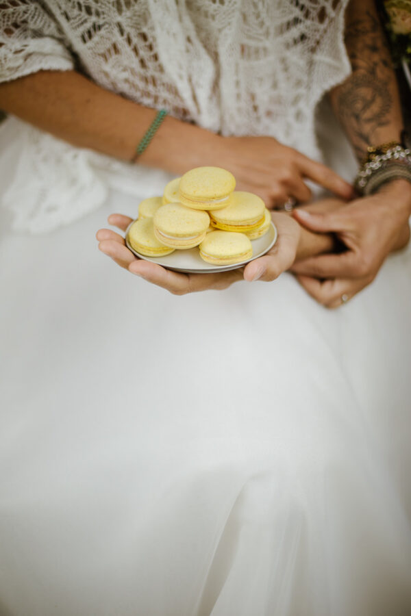 Braut hält Teller mit Zitronen-Macarons – Hochzeitsfotografie Stephanie Wittmer