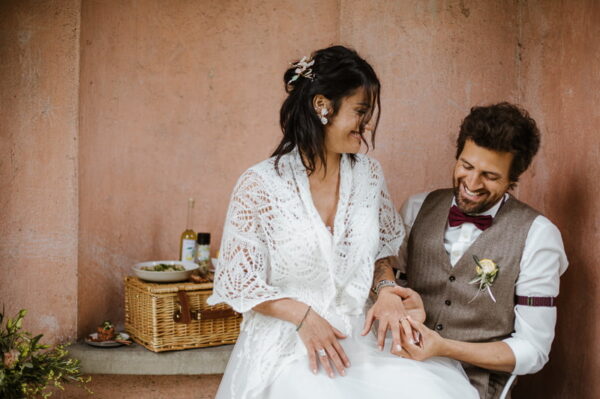 Der Bräutigam betrachtet lachend den Ring seiner Braut.