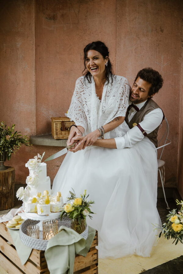 Brautpaar lacht beim Tortenanschnitt – Hochzeitsreportage fotografiert von Stephanie Wittmer Fotografie